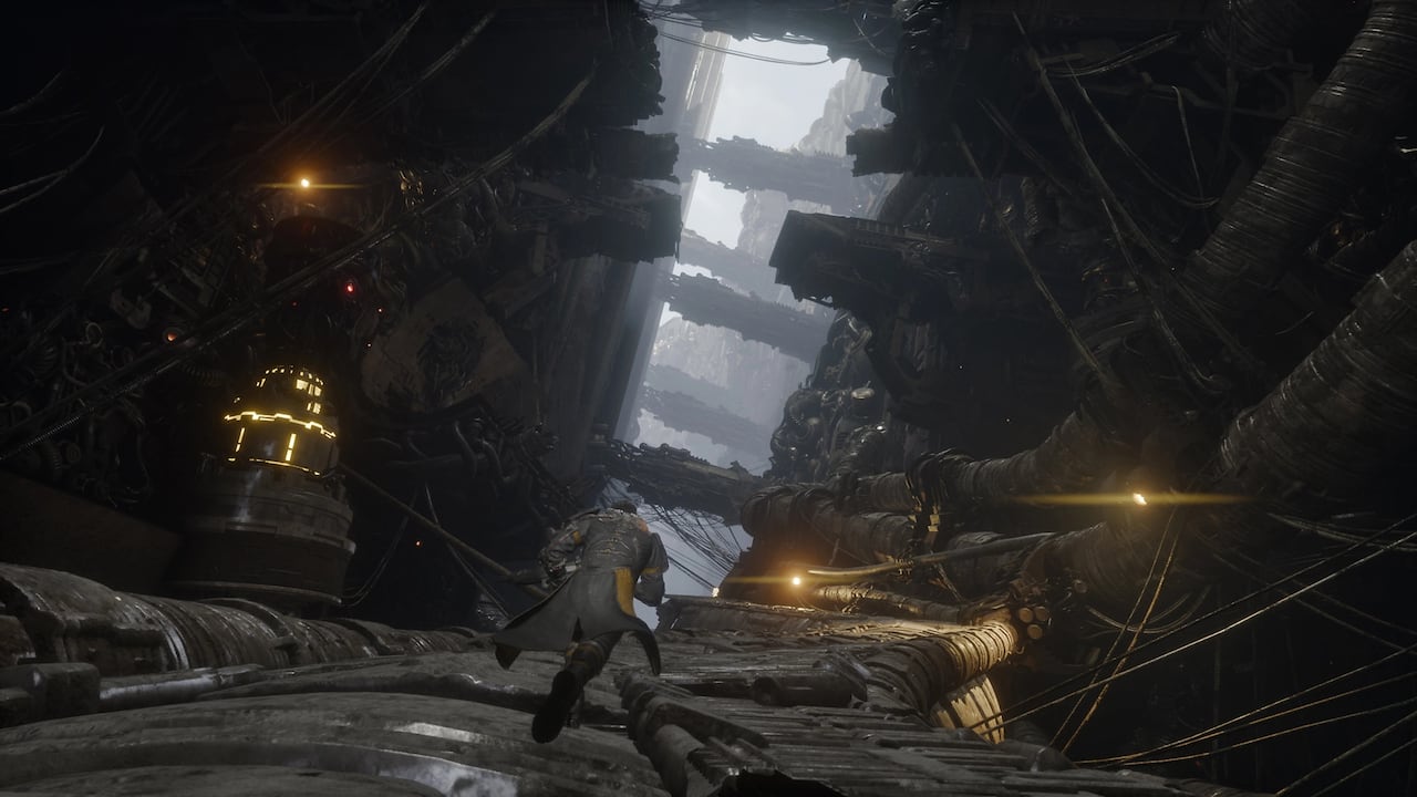 video game screenshot of a man in armour running along big cables.