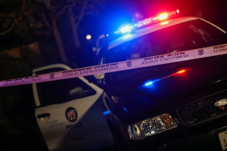 a police car with lights parked behind caution tape