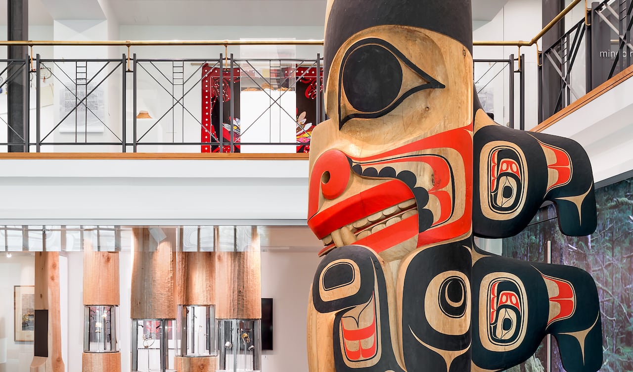 A totem pole standing in an art gallery.