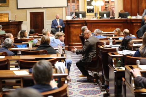 Brandon Newton a Republican representative and Todd Rutherford, a Democratic representative, talk across the aisle in a legislative chamber.