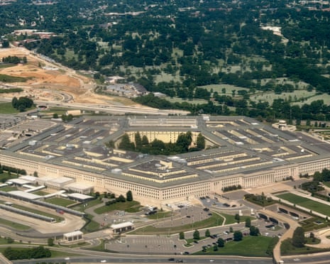 An aerial view of the Pentagon in Arlington showing its distinctive five-sided structure surrounded by parking lots and highways.